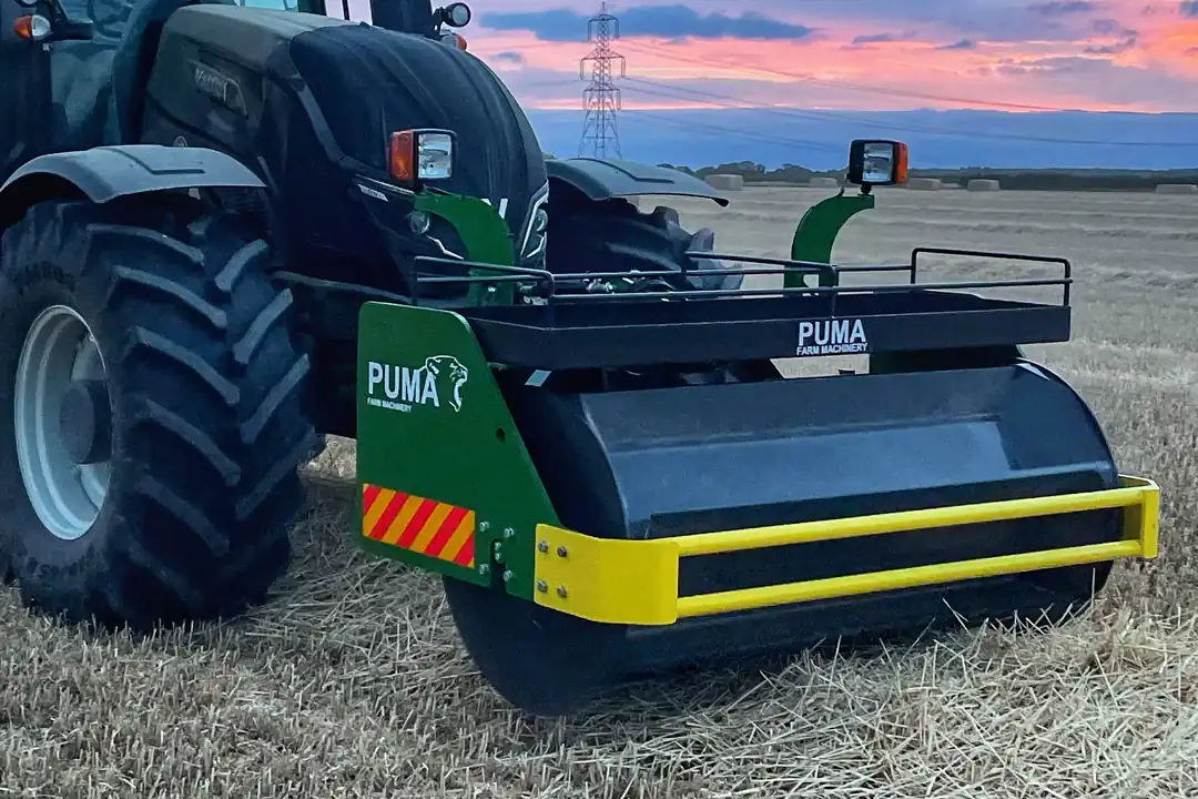 PUMA swath roller mounted on the front of a tractor in a stubble field